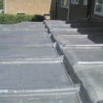 Roof waterproofing with protective coating on a residential building.