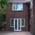 Modern brick extension with double doors and windows by ConstrucTek.