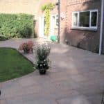 Outdoor patio and garden area with paving, plants, and exterior lighting fixtures.