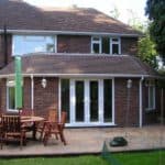 Outdoor brick house with patio and dining set for garden entertaining.