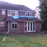 Extension construction with brickwork and large windows.