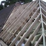 Roof framing with timber trusses and rafters for a residential building.