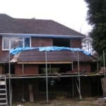 Extension building with scaffolding and protective cover.