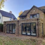 Rear extension with expansive glass doors for natural light and outdoor views in Wrecclesham.