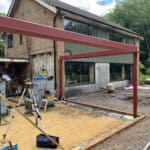 Modern residential extension construction with steel framework in progress.