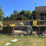 Construction site with scaffolding and safety barriers at a residential building.