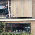 Newly installed wooden cladding on a residential building exterior.
