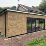 Modern brick extension with large glass sliding doors for enhanced natural light and outdoor views.