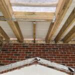 Extension roof framing with timber and insulation in progress.