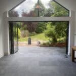 Bright and spacious rear extension featuring floor-to-ceiling glass doors and roof windows for natur.