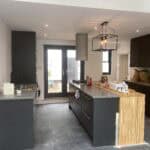 Modern single storey rear extension kitchen with sleek dark cabinetry and wooden accents.