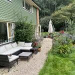 Outdoor garden extension and refurbishment in Normandy with seating and lush greenery.