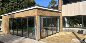 Bright, spacious glass extension with large sliding doors for seamless indoor-outdoor living.