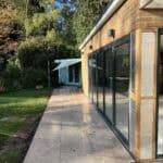 Extension and Refurbishment Normandy - Modern extension featuring expansive glass windows for natura.
