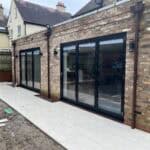 Modern porcelain patio with large glass sliding doors in Wrecclesham.