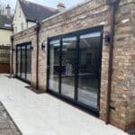 Porcelain patio with large black-framed sliding doors in Wrecclesham, perfect for outdoor living and.
