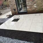 Modern porcelain patio with clean tiles outside a brick house in Wrecclesham.