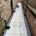 New porcelain patio laid between brick walls in Wrecclesham garden.