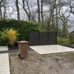 Modern porcelain patio with black privacy screen in Wrecclesham garden.
