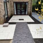Modern porcelain patio with pathway and garden edging in Wrecclesham.