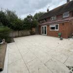 Rear garden with newly constructed single-storey extension in Tongham. Modern paving and outdoor spa.