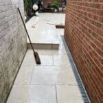 Rear extension patio with new tiled flooring and drainage system in Tongham.