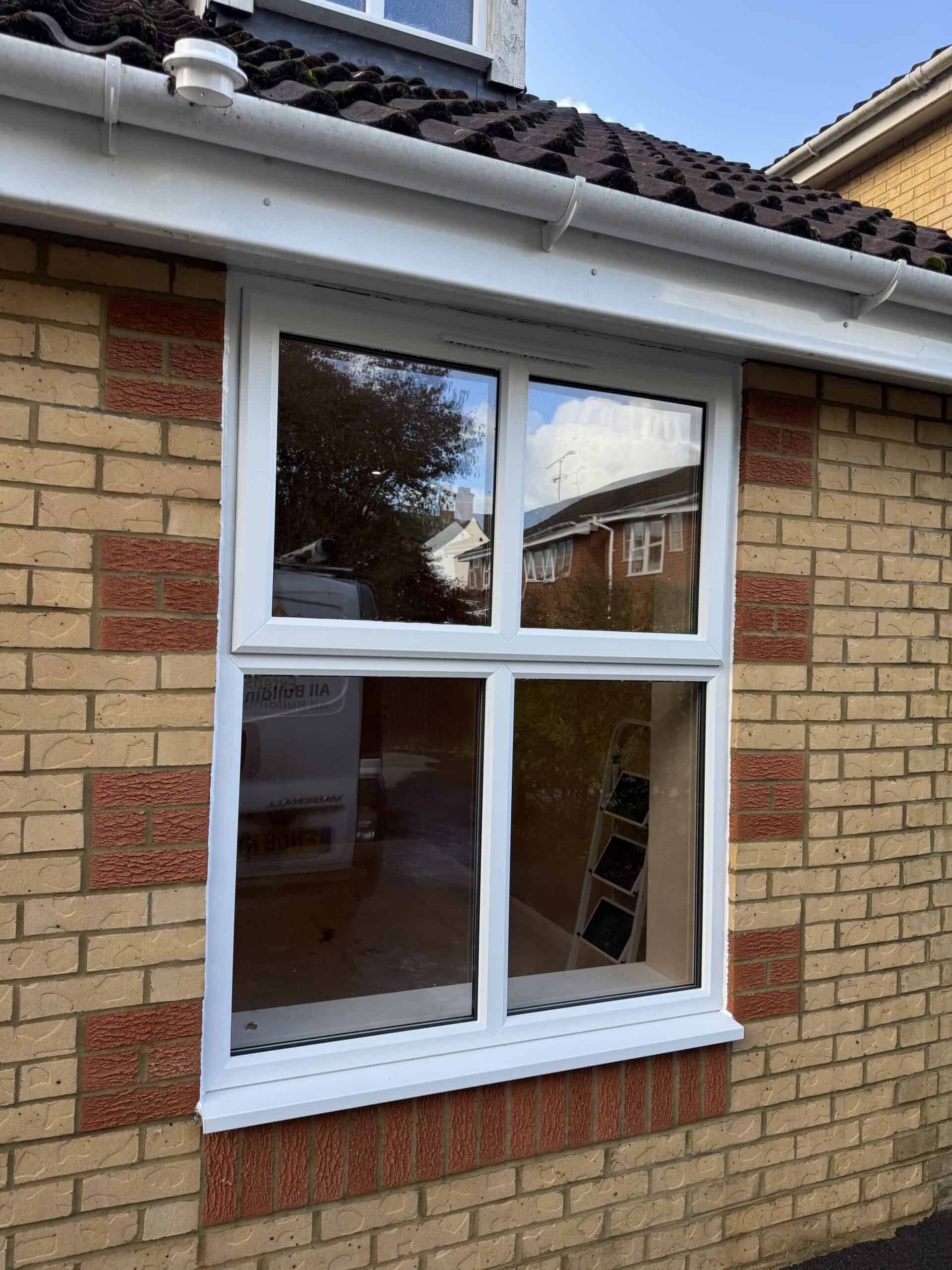 Double-glazed white uPVC window on a brick house in Farnham.