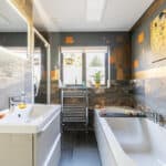 Modern bathroom featuring stone tiles, a bathtub, and contemporary fixtures for a stylish look.