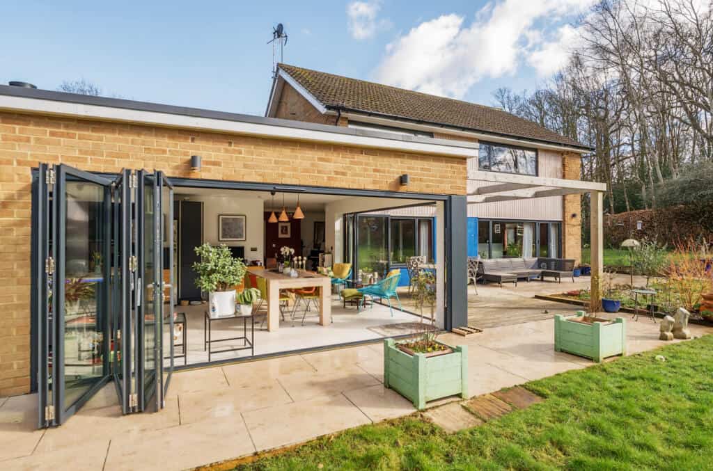 Extended living area with glass walls and outdoor patio for seamless indoor-outdoor living.