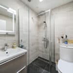 Bathroom with walk-in shower, toilet, and modern fixtures in a contemporary design.