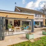 Contemporary home extension featuring large folding glass doors and outdoor patio area.