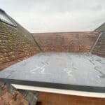 New single-ply flat roof between the existing roofs