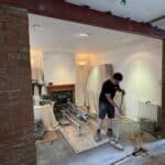 Load-bearing wall removed with a new steel beam on brick piers, opening the kitchen into the dining room