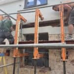 Wraparound extension and garage conversion in Farnham – steel beams going in across the back wall, house propped