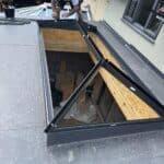 Wraparound extension and garage conversion in Farnham – roof lantern being fitted on the flat roof