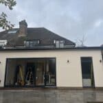 Wraparound extension and garage conversion in Farnham – finished rear: bifold doors and through-coloured render